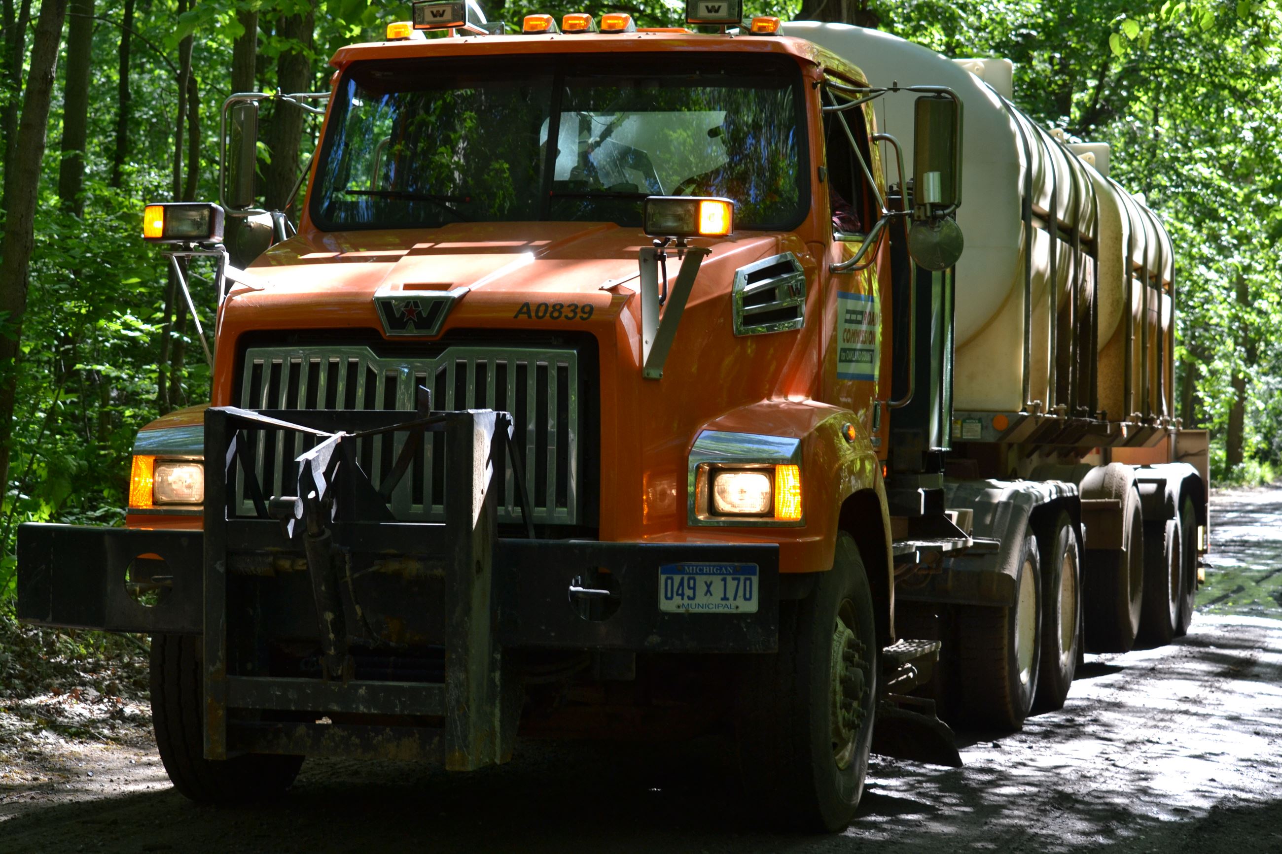 RCOC truck applying brine to a gravel road