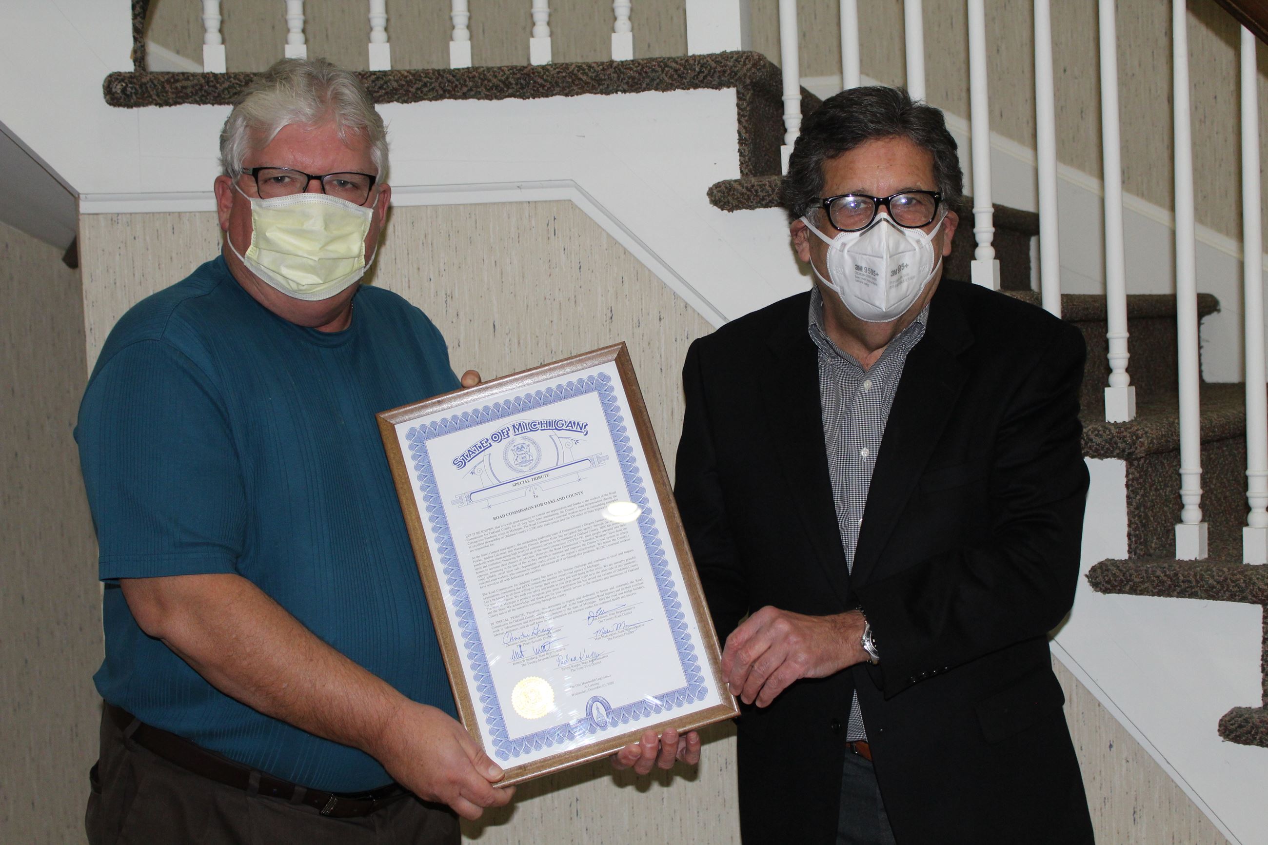 Greg Jamian (right) and Dennis Kolar display state tribute recognizing R.C.O.C. workers during pande
